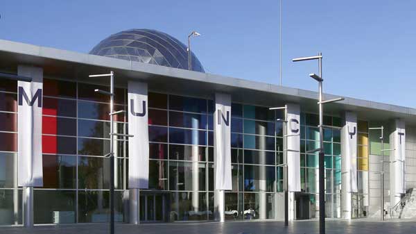 Modern Bradford International Virtual School building with colorful flags and glass facade